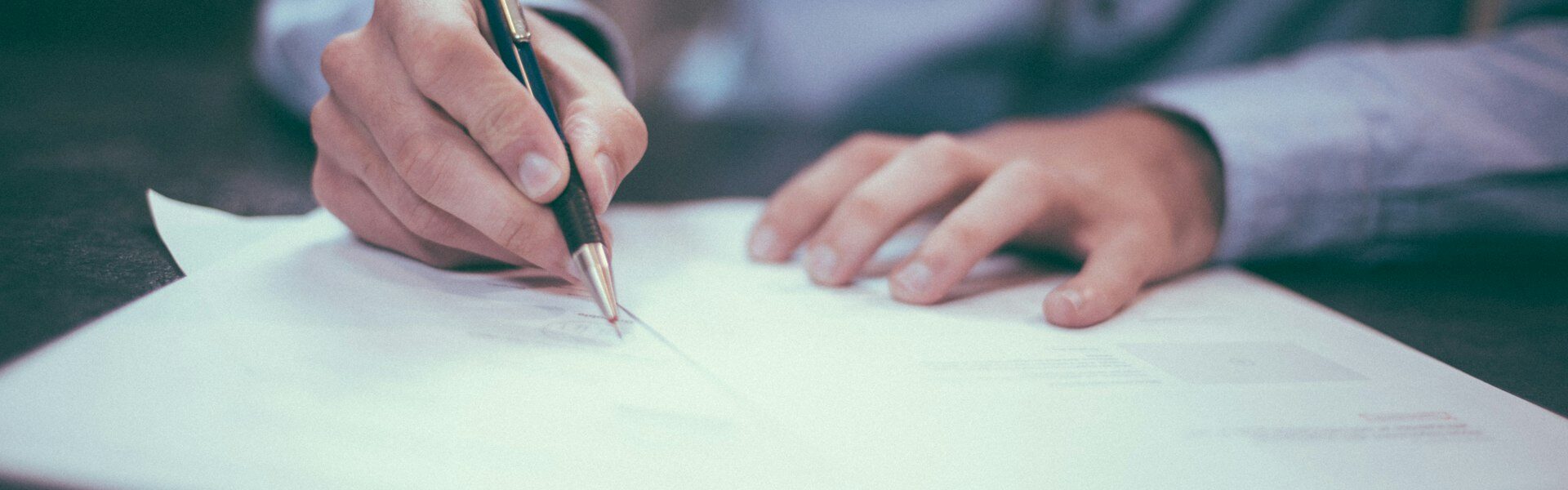 Podpisywanie umowy długopisem przy biurku