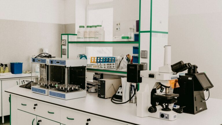 Stół laboratoryjny z mikroskopem i aparaturą w jasnym laboratorium